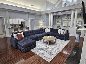 A large blue couch with a wooden coffee table in front of it.